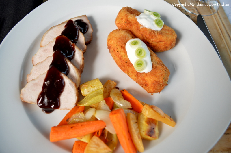 Pork Loin Roast with Pomegranate, Red Wine, and Black Garlic Sauce served with Potato Croquettes and Roasted Root Vegetables