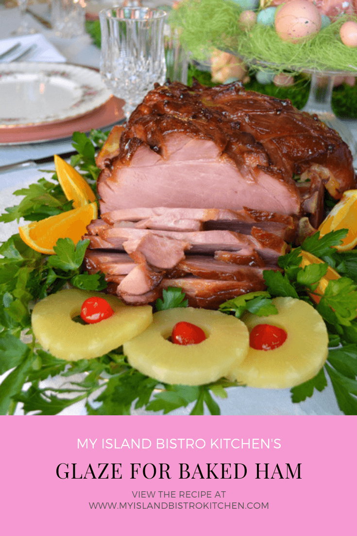 Glazed Baked Ham on a bed of greens surrounded by orange wedges and pineapple slices