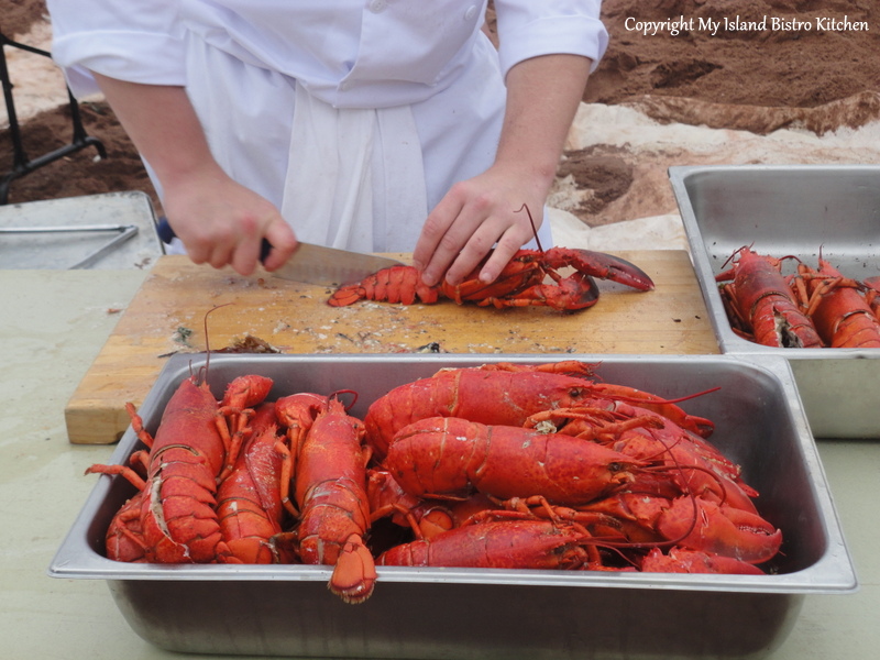 Cracking open the lobsters at the Lobster Party on the Beach at Cedar Dunes Park, West Point, PEI (2013)
