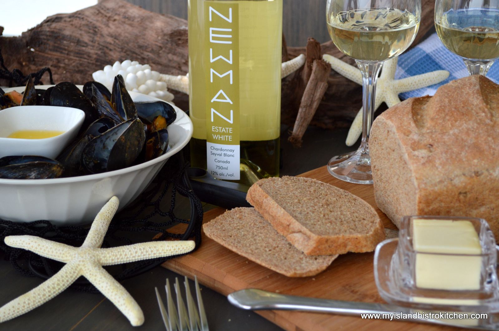 Bowl of Island Blue Mussels, Bottle of PEI produced wine, and a loaf of multigrain bread