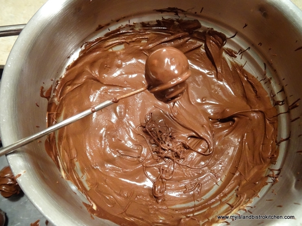 Using a spiral swirl candy dipper to coat chocolate peanut butter balls