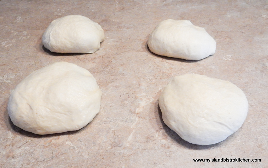 Four rough circles of dough on beige counter