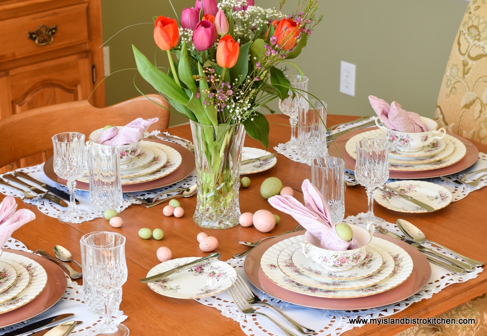 Maple table is set with Royal Albert's Lavender Rose dinnerware. Centerpiece is a large bouquet of pink and orange tulips in tall glass vase