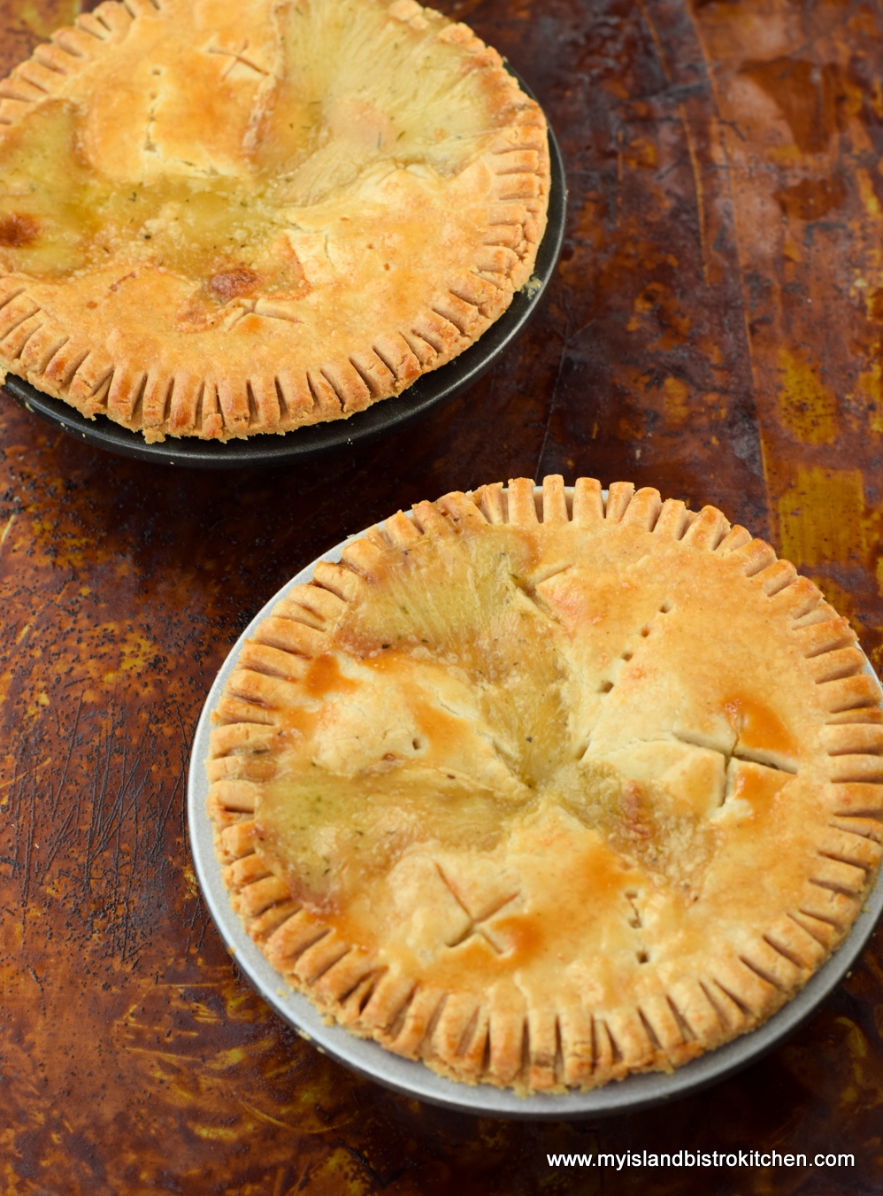 Two baked Chicken Pot Pies on brown background