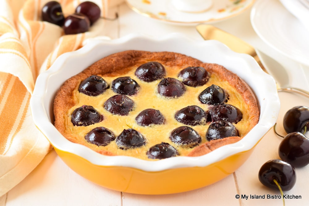 Yellow ceramic pie plate filled with Cherry Clafoutis