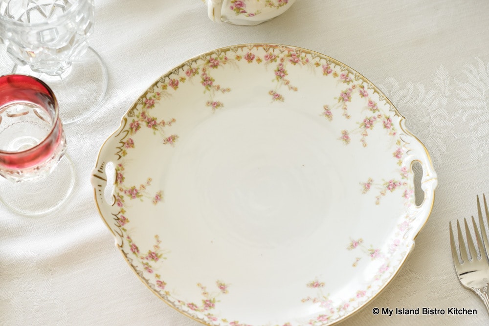 Top-down view of white serving plate with a border of tiny pink roses