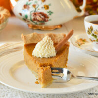 Slice of pumpkin pie with a dollop of whipped cream on top