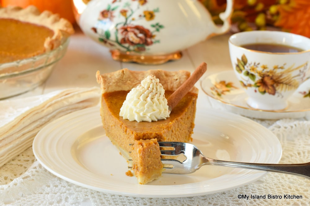 Slice of pumpkin pie with a dollop of whipped cream on top