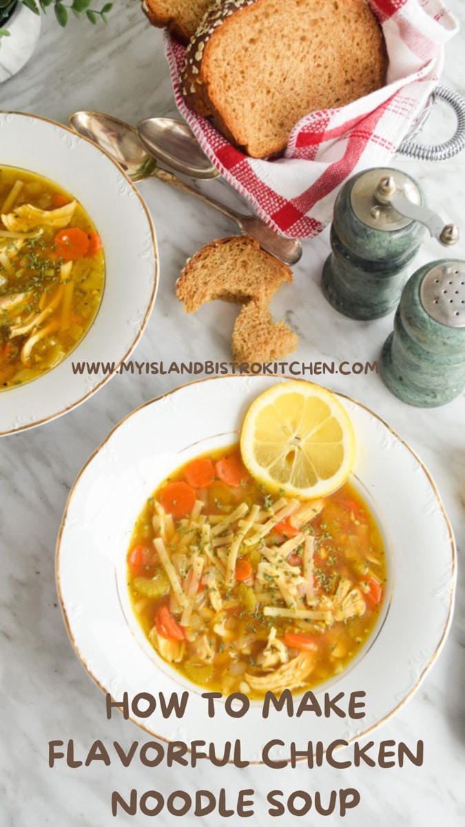 White bowls filled with homemade chicken soup alongside a basket of homemade bread