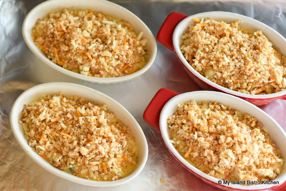Individual Seafood Casseroles topped with bread crumbs and cheddar cheese