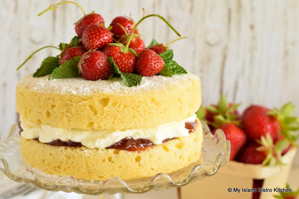 Sponge Cake filled with jam and whipped cream and topped with fresh strawberries
