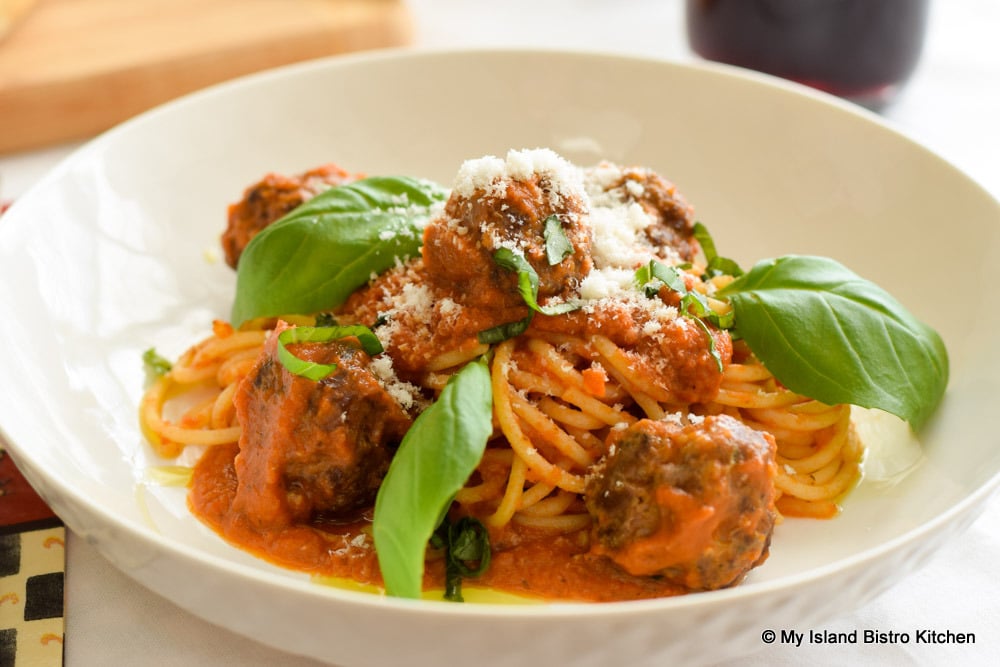 Bowl full of Spaghetti and Meatballs garnished with fresh basil