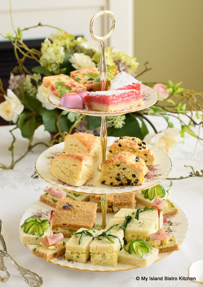 A bountiful three-tier serve filled with teatime sandwiches, scones, and pastries