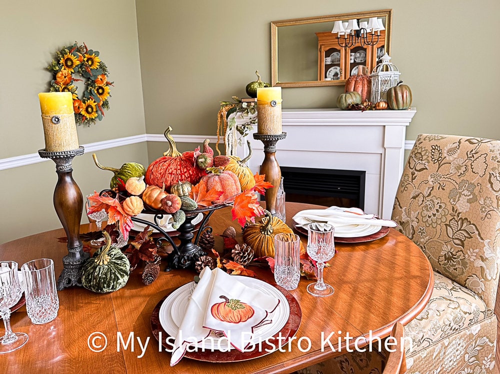 Colorful Thanksgiving Tablesetting featuring brightly colored velvet pumpkins and napkins with a pumpkin motif