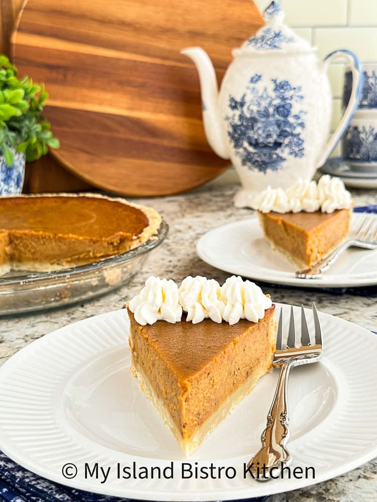 Slice of Sweet Potato Pie with whipped cream sits on plate.