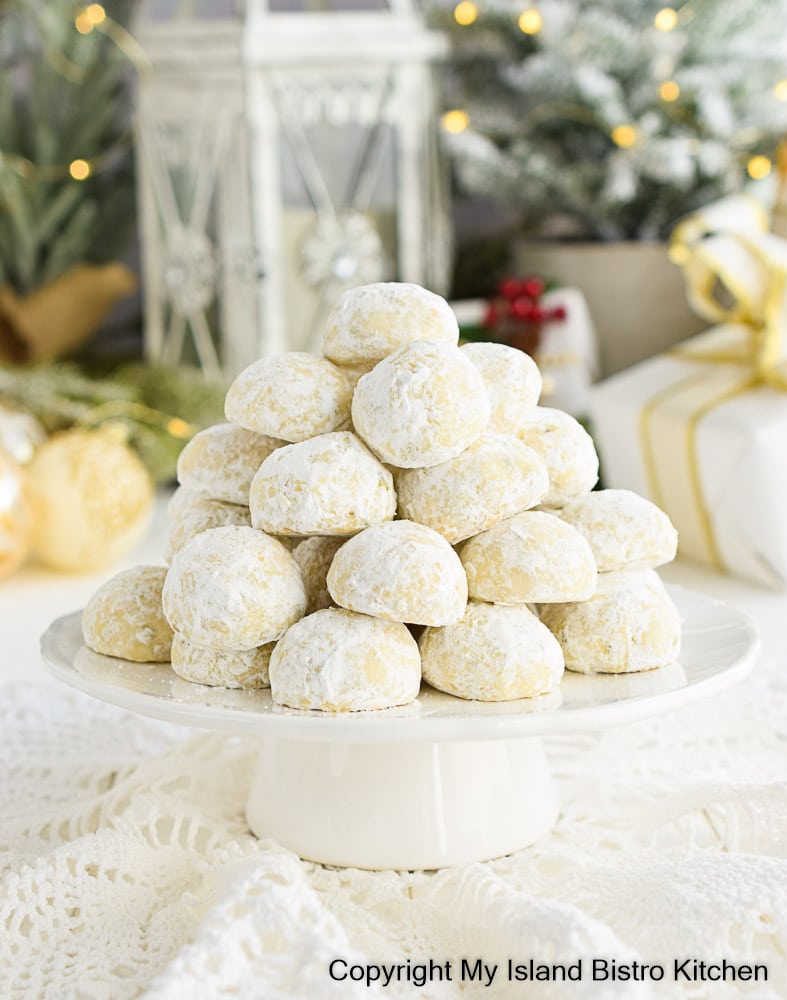 Russian Tea Cakes placed in pyramid shape on a white pedestal cake plate