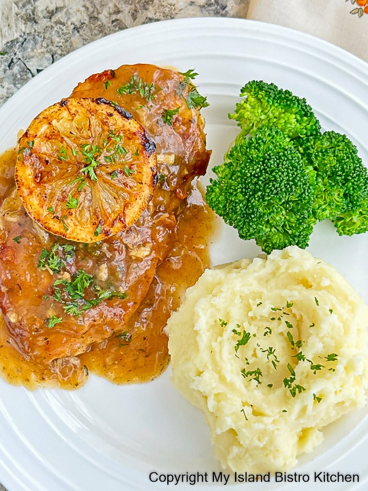 Chicken Française topped with a caramelized lemon slice served alongside steamed broccoli and whipped potatoes