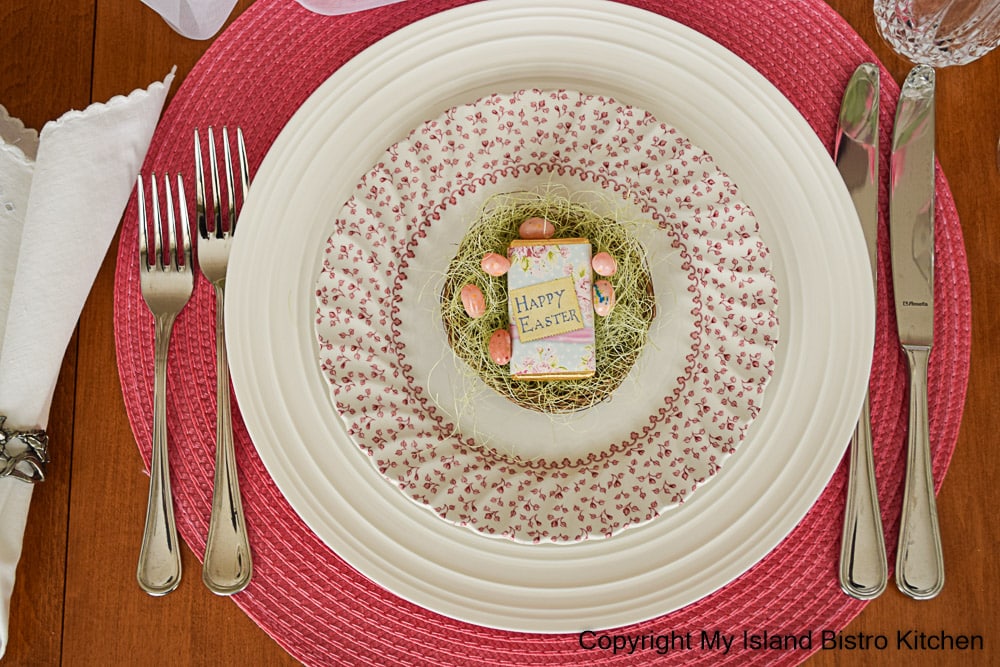 Mix and match dinnerware adds interest to a casual tablesetting. Here, a pink and white salad plate sits atop a plain white dinner plate.