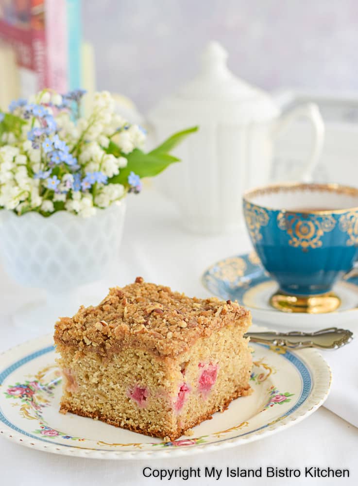 Homemade Rhubarb Cake on antique plate with teacup in background