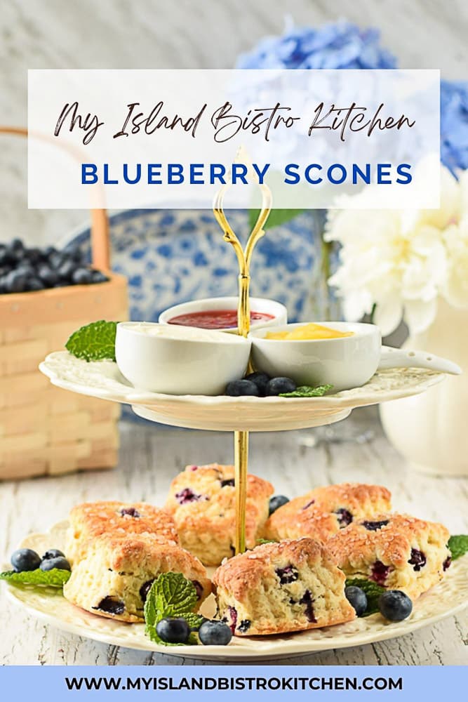 Two-tiered server filled with scones with jam, lemon curd, and English double cream