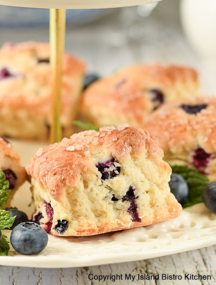 Homemade scones surrounded by blueberries on serving plate 