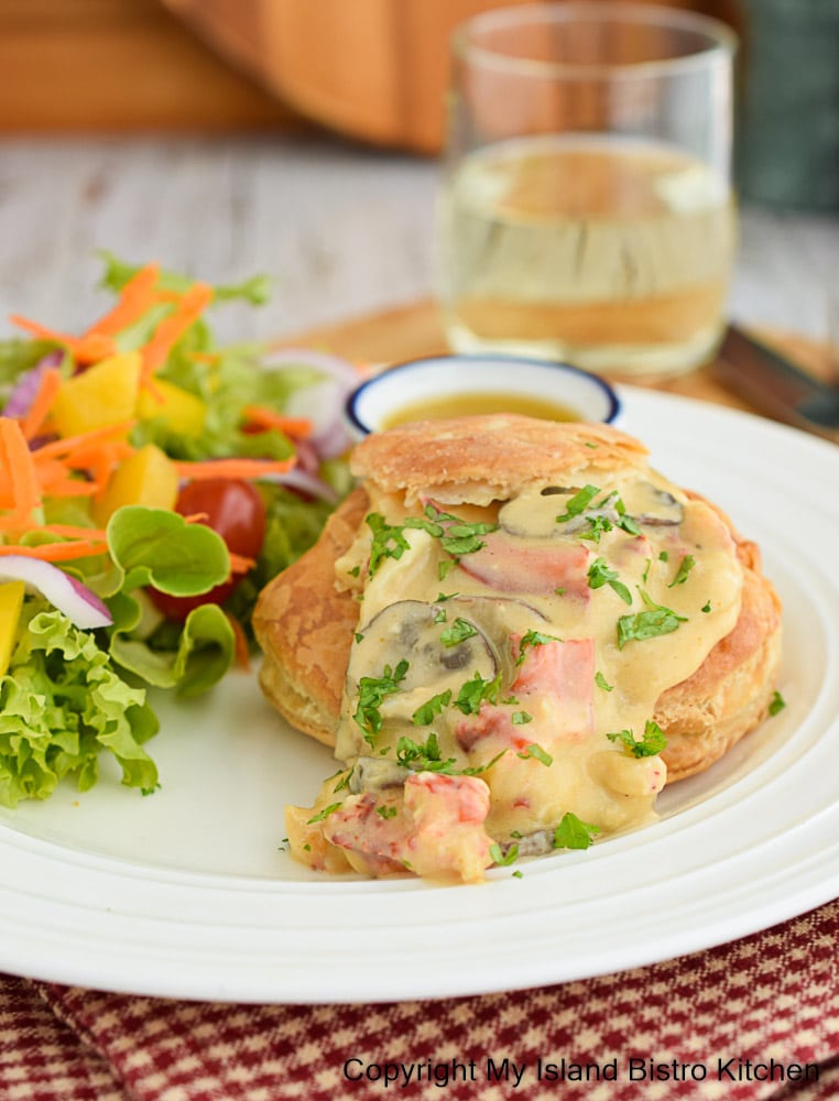 Lobster in a Cream Sauce served in puff pastry shells alongside a mixed green salad