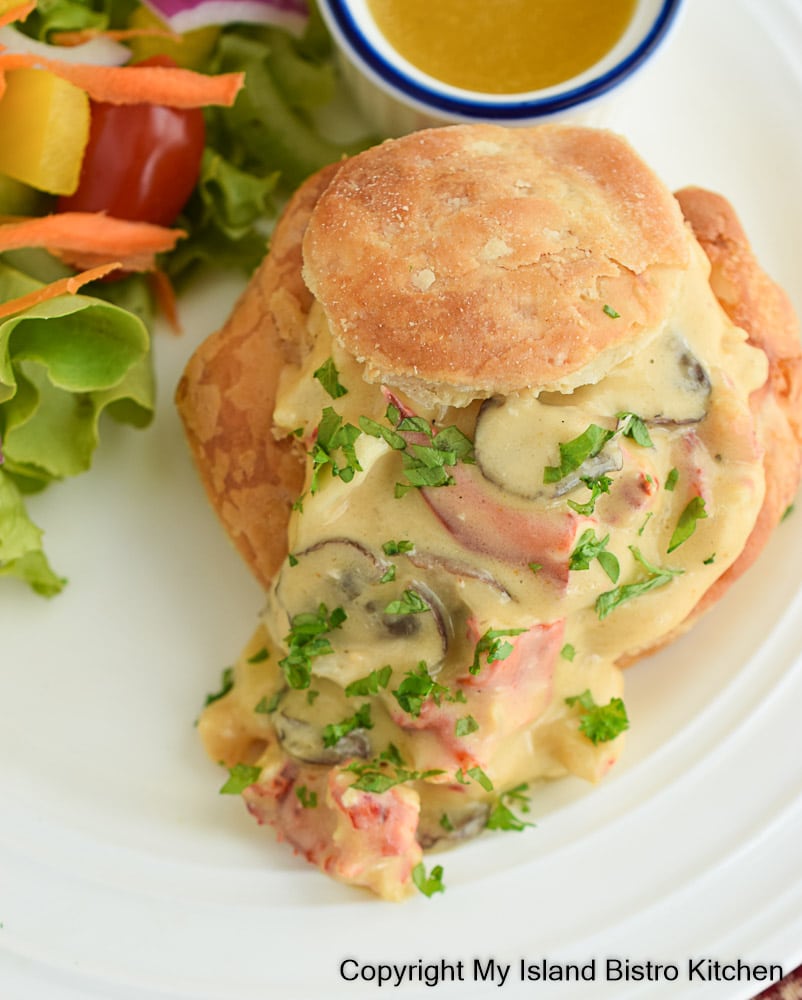 Top down view of creamed lobster spilling out of puffed pastry shell