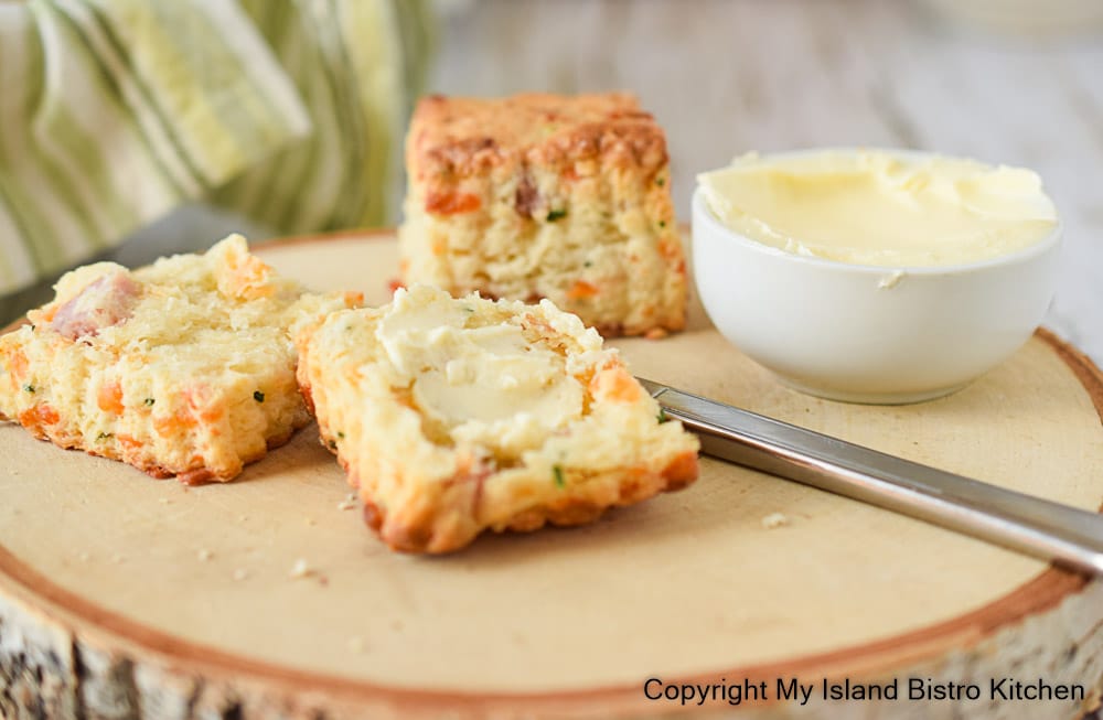 Savory scones and butter sit atop a wooden board