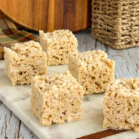 Squares of Rice Krispies Treats sit atop a marble server