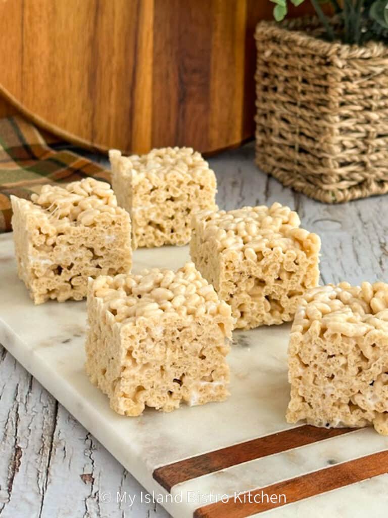 Squares of Rice Krispies Treats sit atop a marble server