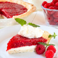 Slice of Pie with a layer of cream cheese and a rich red raspberry topping