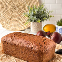 A quick bread sits atop parchment paper with beets in the background